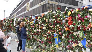 Personas dejan flores en sitio cercano al atentado de Estocolmo.