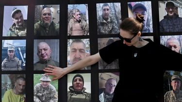 Una joven toca retratos durante una manifestación de familiares y amigos de prisioneros de guerra ucranianos bajo el lema ¿Dónde estás?, que pide acelerar su intercambio, en la Plaza de la Independencia de Kiev el 15 de junio de 2025.