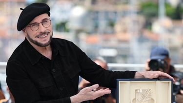 El actor, director y guionista John Travolta posa con la Palma de Oro honorífica que otorga el Festival de Cine de Cannes.