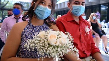 Parejas de recién casados con máscarillas faciales contraen nupcias durante una boda masiva de 44 parejas organizada por el municipio durante la celebración del Día de San Valentín, en el Parque Cuscatlán, en San Salvador, el 14 de febrero de 2021, en medio de la pandemia del COVID.
