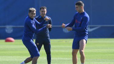 Los jugadores del Barcelona, Raphinha (izquierda) y Ferran Torres (derecha), junto con el entrenador Xavi Hernández (centro) en una práctica del club.