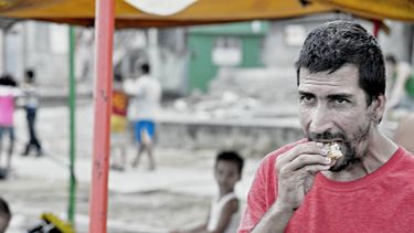 Un hombre come un trozo de pan en el oriente de Cuba. 