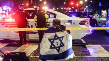 Un hombre con una bandera israelí este jueves en el lugar donde fueron asesinadas dos personas que trabajaban en la embajada de Israel en Washington.&nbsp;&nbsp;