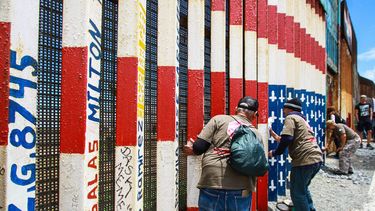 &nbsp;Seguidores y miembros del grupo Veteranos Deportados Unidos ayudan a repintar un mural en el que se dibujó una bandera estadounidense al revés.&nbsp;