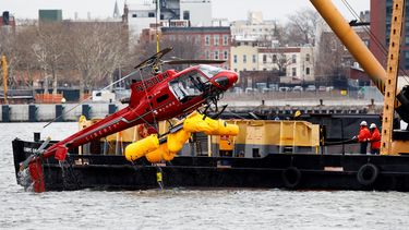 Una grúa saca al helicóptero del estrecho del East River de Nueva York.
