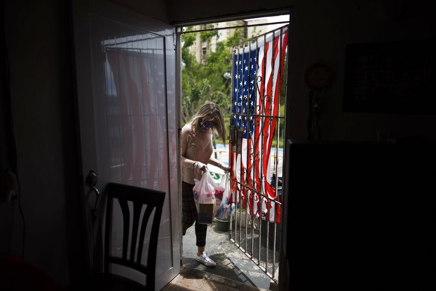 Una voluntaria trae ayuda a una familia necesitada en medio de la crisis del coronavirus en San Juan, Puerto Rico, el 29 de abril del 2020.