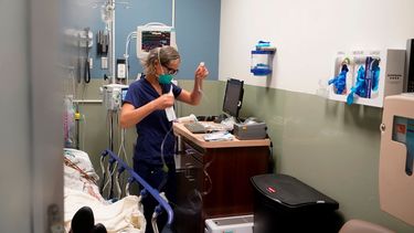 La enfermera Sandra Younan prepara una línea intravenosa para un paciente.