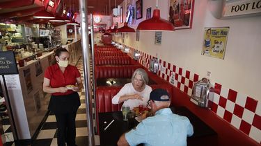 Lynn Tanner (al centro) y su esposo Ryan (derecha) almuerzan en el restaurante Busy Bee Cafe el jueves 21 de mayo de 2020, en Ventura, California.&nbsp;