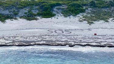 Las letras SOS sobresalen en la isla desierta donde fue rescatado un náufrago en las Bahamas.