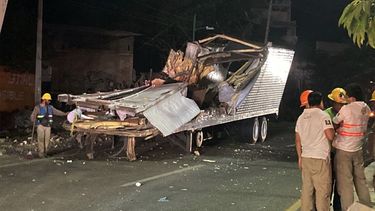 Los trabajadores retiran el contenedor del remolque de un camión que se estrelló con migrantes a bordo durante un accidente de tránsito en Tuxtla Gutiérrez, estado de Chiapas, México, el 9 de diciembre de 2021.