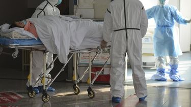 Personal médico, vestidos con trajes de protección, trasladan a un paciente afectado por un coronavirus a una zona de aislamiento en un hospital de Fuyang, en la provincia de Anhui, en el centro de China, el 1 de febrero de 2020. (Chinatopix via AP)