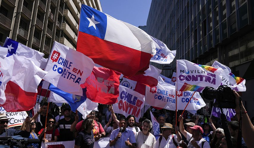 Chilenos enarbolan banderas y pancartas para mniafestar su rechazo a la propuesta constitucional 2023.