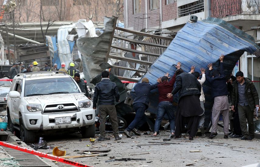 La gente intenta eliminar los restos de la escena de un atentado suicida con bomba en Kabul, Afganistán, el 27 de enero de 2018.