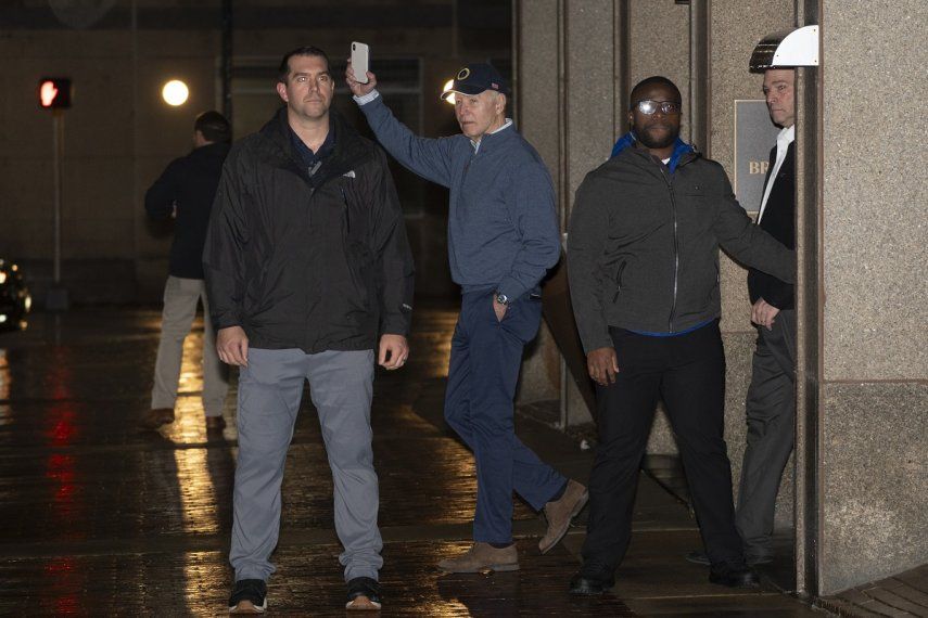 El presidente Joe Biden saluda mientras agentes del Servicio Secreto lo protegen a su salida de su sede de campaña el domingo 17 de diciembre de 2023, en Wilmington, Delaware.&nbsp;