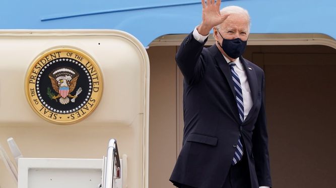 El presidente Joe Biden saluda en lo alto de la escalinata del avión presidencial Air Force One.
