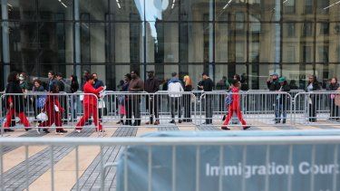 Migrantes esperan en fila para entrar al tribunal de inmigración en el Edificio Federal Jacob K. Javits el 22 de octubre de 2025 en la ciudad de Nueva York.