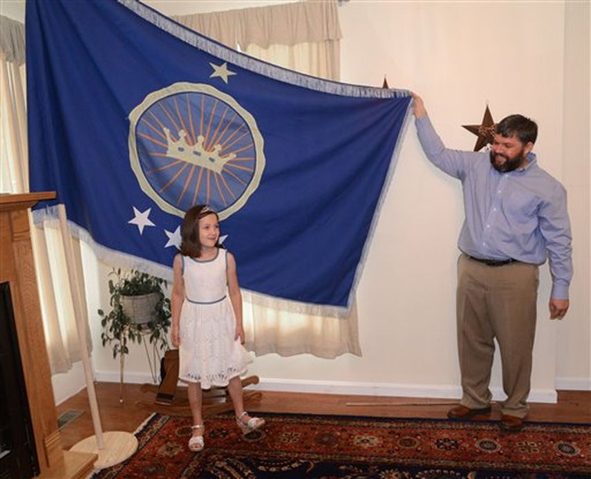 Jeremiah Heaton y su hija de 7 años, la princesa Emily, muestran la bandera de su reino el 2 de julio del 2014 en Abingdon, Virginia, que su familia creó en momentos que tratan de reclamar un territorio en la región de Bir Tawil, en el oriente de Afric