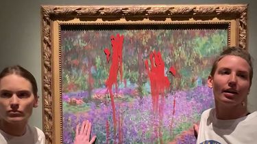 Esta captura de imágenes proporcionadas por la red de acción Aterstall Vatmarker el 14 de junio de 2023 muestra a dos mujeres de pie junto a la obra El jardín del artista en Giverny (1900) del artista francés Claude Monet (1840-1926) después de haber manchado pintura en él en el Museo Nacional de Estocolmo, Suecia.