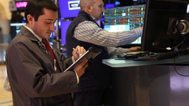 Agentes de la Bolsa de Nueva York trabajan en el piso de remate.