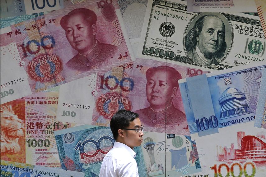 Un hombre camina frente a una casa de cambio, decorada con distintos billetes, en el distrito financiero de Hong Kong.&nbsp;