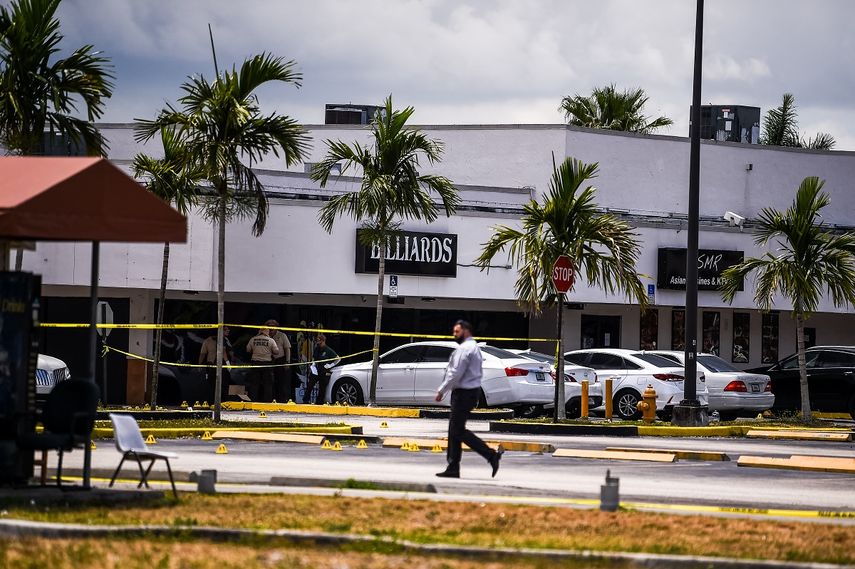 Agentes de la policía de Miami Dade recolectan evidencia del estacionamiento frente al club de Billar que fue alquilado para un concierto.