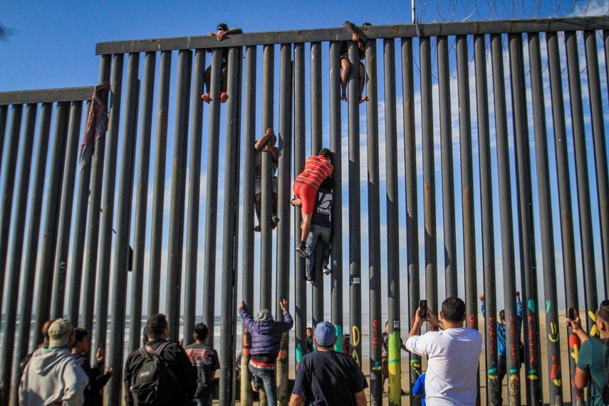 Migrantes escalan muro en noroeste de México y cruzan ilegalmente a EEUU.