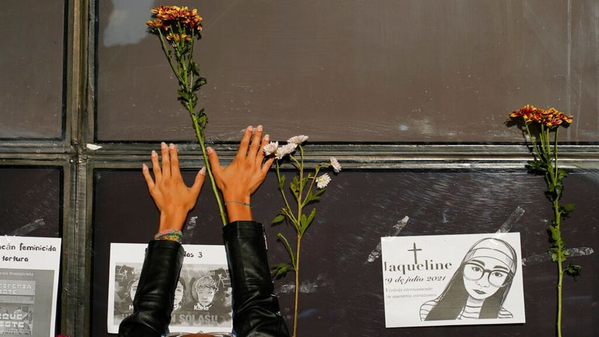 Una mujer coloca flores en la fachada de la Fiscalía General de la República durante una protesta por la desaparición de Debanhi Escobar y otras mujeres.