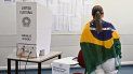Una mujer envuelta en una bandera brasileña vota en un centro de votación durante las elecciones legislativas y presidenciales en Brasilia, Brasil, el 2 de octubre de 2022.   