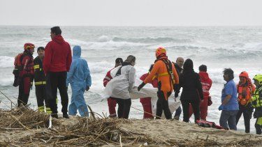Rescatistas recuperan un cadáver de una playa cercana a Cutro, en el sur de Italia, el domingo 26 de febrero de 2023, después de que un bote de migrantes se partió en un mar picado.&nbsp;