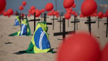 Cruces, globos rojos y la bandera de Brasil son colocados en la playa de Copacabana por el organismo no gubernamental Río de Paz en honor a las víctimas de COVID-19, en Río de Janeiro, Brasil, el sábado 8 de agosto de 2020.&nbsp;