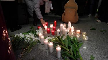 Una mujer pone una vela mientras la gente se reúne para una vigilia en honor a las víctimas del accidente de tren de alta velocidad del 18 de enero, que causó la muerte de 45 personas en Adamuz, el 25 de enero de 2026, en la estación de tren de Huelva (España)