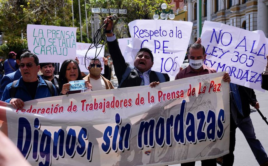 Periodistas de la Federación de Prensa de La Paz sostienen una pancarta mientras protestan contra una propuesta de ley impulsada por los legisladores del oficialismo que regularía a la prensa frente al palacio de gobierno en La Paz, Bolivia, el miércoles 12 de abril de 2023.