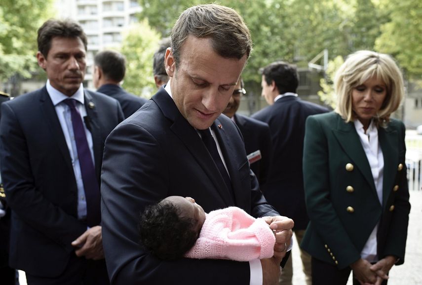 El presidente Emmanuel&nbsp;Macron sostiene en brazos a un recién nacido, durante su visita al hospital pediátrico Robert Debre en París.