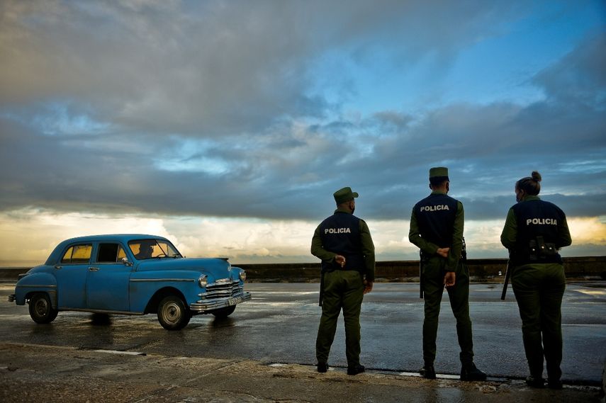 Agentes de policía observan cómo el mar golpea contra el malecón de La Habana, el Malecón, el 9 de noviembre de 2020.