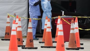Trabajadores de la salud se ayudan mutuamente a colocarse equipo protector en un sitio de testeo del coronavirus en Miami Gardens, Florida, 5 de julio de 2020. El equipo protector para los trabajadores que atienden a enfermos de COVID-19 vuelve a escasear.&nbsp;