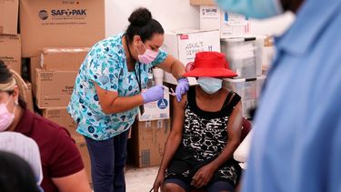 En esta fotografía de archivo del 10 de abril de 2021, la enfermera Ashleigh Velasco, aplica una vacuna de Johnson & Johnson contra el COVID-19 a Rosemene Lordeus, a la derecha, en una clínica a cargo de Health Network, en Immokalee, Florida.
