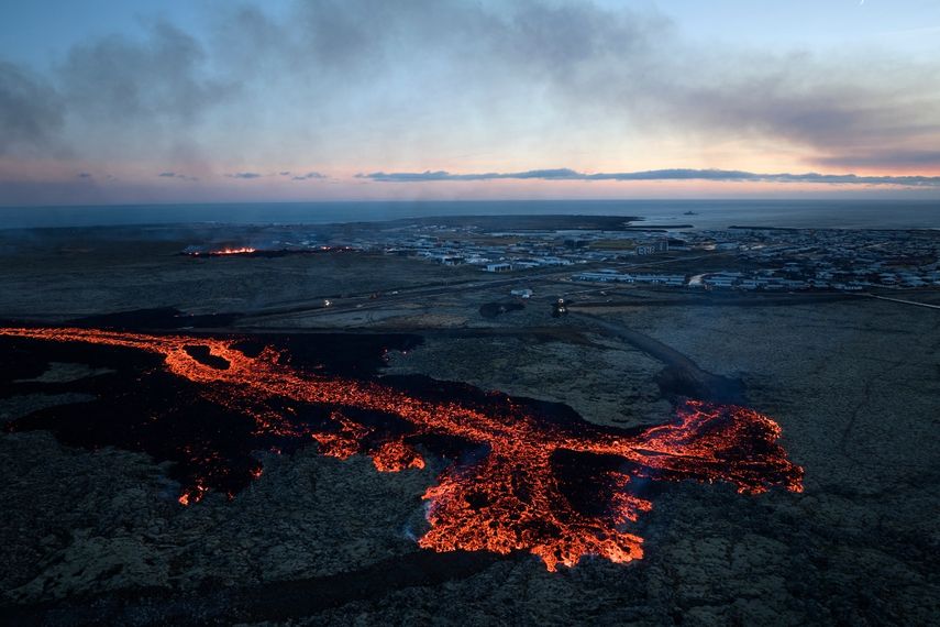 Explosiones de lava y ondas de humo cerca de edificios residenciales en la ciudad de Grindavik, en el suroeste de Islandia, después de una erupción volcánica el 14 de enero de 2024.