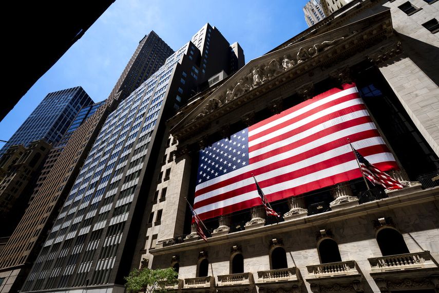 El frente de la sede de la Bolsa de Nueva York con una gran bandera de EEUU.