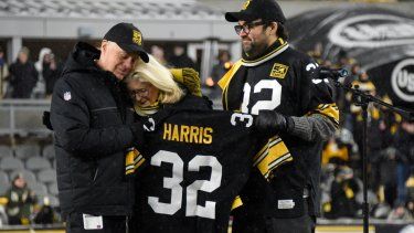 Art Rooney II, izquierda, presidente de los Steelers de Pittsburgh, la viuda de Franco Harris, Dana, centro, y su hijo Dok, asistieron a la ceremonia del retiro del jersey con el número 32 de Harris al medio tiempo del juego de la NFL en contra de los Raiders de Las Vegas, el sábado 24 de diciembre de 2022.