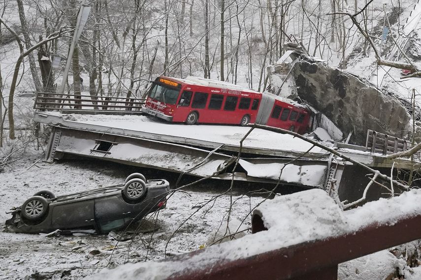 Un autobús de la Autoridad Portuaria y otro automóvil que estaban en un puente cuando se derrumbó el viernes 28 de enero de 2022 son visibles en el East End de Pittsburgh. Cuando el puente se derrumbó, los rescatistas descendieron casi 150 pies mientras otros formaban una cadena humana para ayudar a rescatar a varias personas del autobús que colgaba.&nbsp;