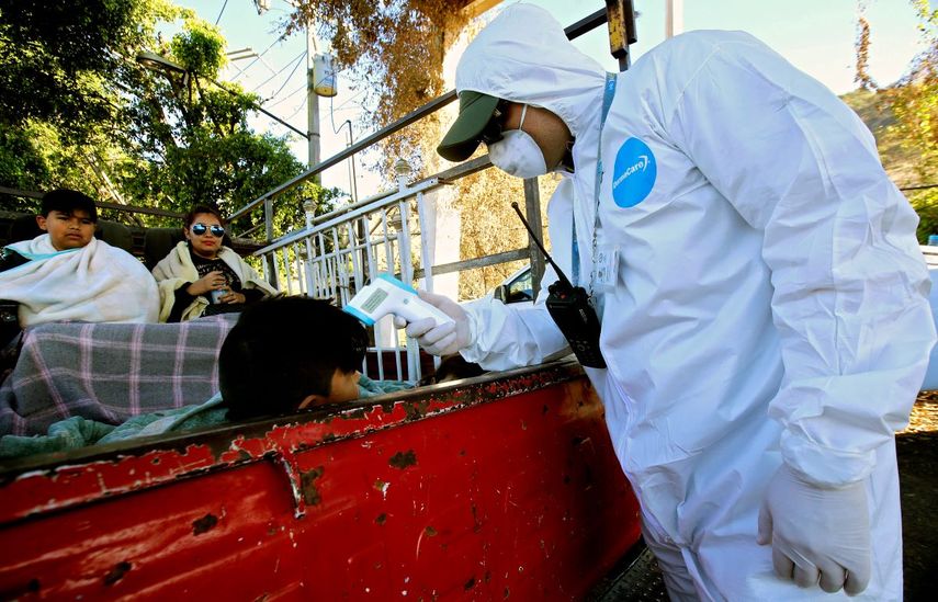 Un empleado de la Secretar&iacute;a de Salud de M&eacute;xico verifica la temperatura de un ni&ntilde;o a bordo de un cami&oacute;n como medida preventiva contra la&nbsp; propagaci&oacute;n del nuevo coronavirus, COVID-19, en la carretera a Puerto Vallarta, en Zapopan, estado de Jalisco, M&eacute;xico, el 7 de abril 2020. La OPS ha alertado a los gobiernos que vienen semanas dif&iacute;ciles por la pandemia.