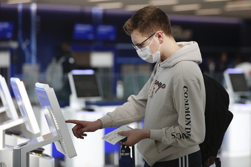 El estudiante universitario en Nueva York Hector Medrano, de Los &Aacute;ngeles, factura en su vuelo con una pantalla t&aacute;ctil, el s&aacute;bado 14 de marzo de 2020 en la terminal de jetBlue, en el aeropuerto John F. Kennedy International en Nueva York.&nbsp;