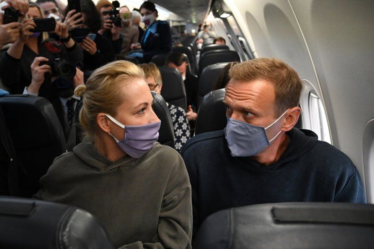El líder de la oposición rusa Alexei Navalny y su esposa Yulia se sientan en un avión de la aerolínea Pobeda que se dirige a Moscú antes del despegue del aeropuerto de Berlín Brandenburgo (BER) en Schoenefeld, al sureste de Berlín, el 17 de enero de 2021.  