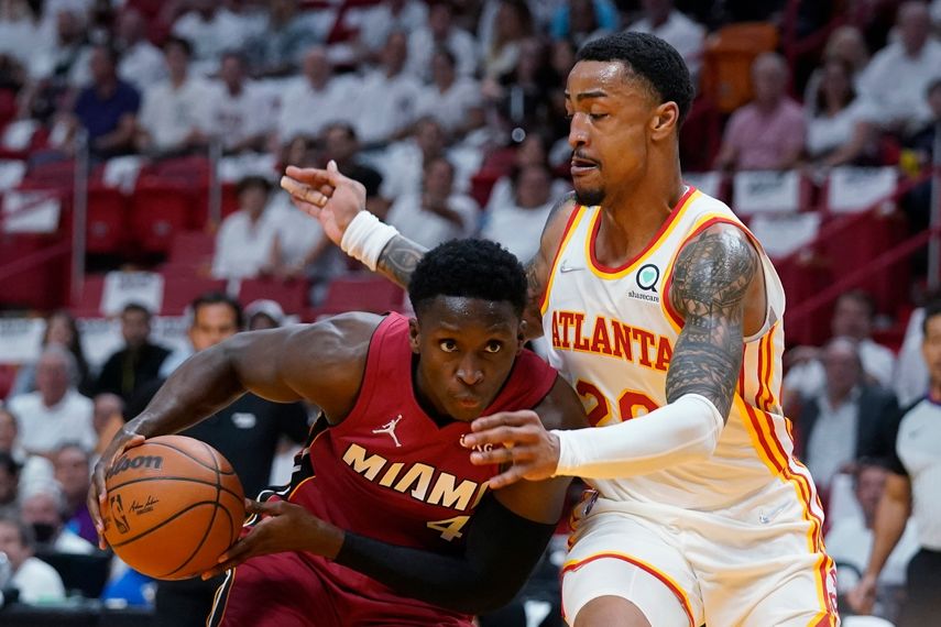 El base del Heat de Miami Victor Oladipo avanza hacia la canasta mientras lo defiende el alero de los Hawks de Atlanta John Collins en el juego 5 de la serie de primera ronda de la postemporada en la Conferencia Este el martes 26 de abril del 2022.