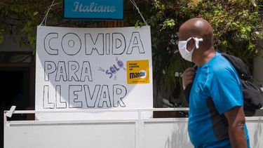Un hombre camina por la acera de un restaurante de comida italiana, en La Habana, Cuba.