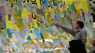 Una persona lee mensajes en los que se desea el regreso con vida de pasajeros del transborador Sewol en Ansan, corea del Sur, Corea del Sur, el jueves 24 de abril de 2014.(AP)
