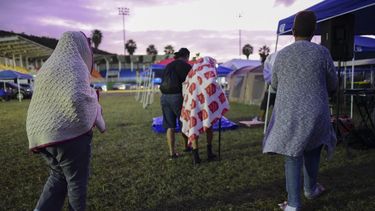 Varias personas se ponen de pie luego de pasar la noche en un estadio de b&eacute;isbol tras un sismo de magnitud 6,4 en Guayanilla, Puerto Rico, el viernes 10 de enero de 2020.&nbsp;