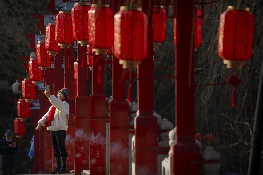 Una mujer se toma una selfie en un puente decorado con linternas en un parque pública en Beijing en el primer día de la fiesta del Año Nuevo Lunar, el domingo 22 de enero de 2023.&nbsp;