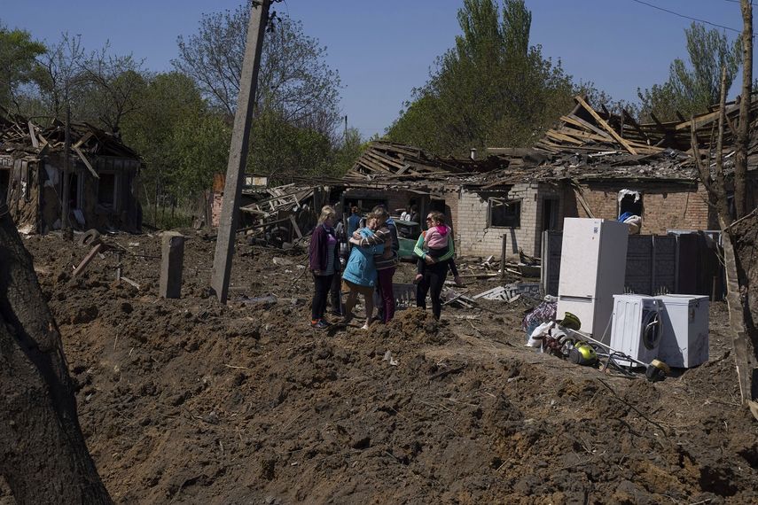 Varias personas reaccionan junto a un cráter en una zona residencial destruida después de un ataque aéreo ruso en Bakhmut, en la región ucraniana de Donetsk, el sábado 7 de mayo de 2022.&nbsp;