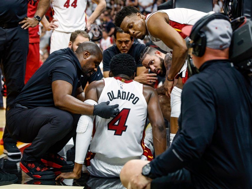 Compañeros y personal del Heat de Miami atienden a Victor Oladipo (4) que sufrió una lesión en un juego ante los Bucks de Milwaukee, el sábado 22 de abril de 2023, en Miami.&nbsp;